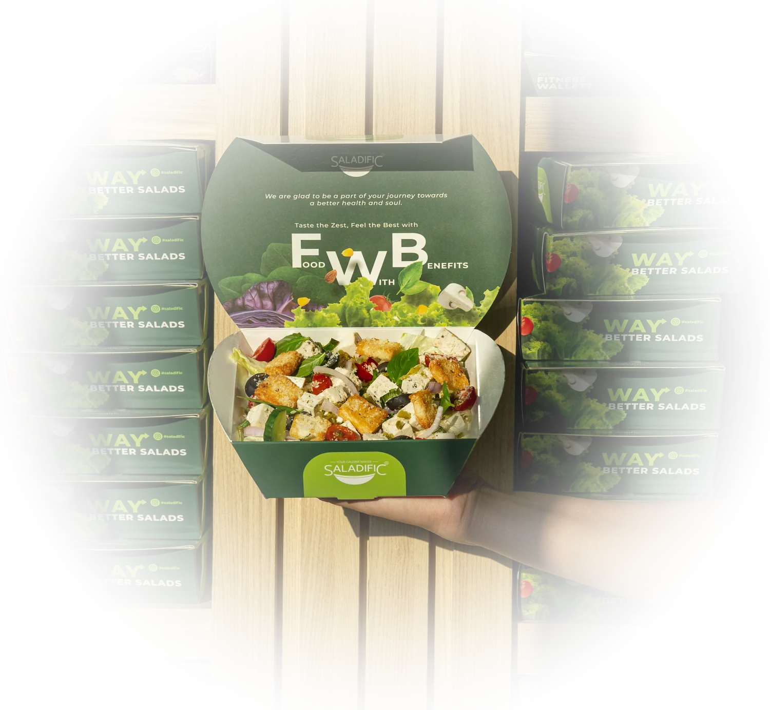 A Saladific salad box held open in front of a shelf of packed salads